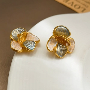 Macro shot of S925 silver flower stud earrings with grey and orange enamel and gold rim