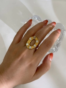 Macro detail of hexagonal 18K gold plated steel ring with white shell inlay on finger