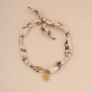 Elegant silk ribbon choker necklace with gold daisy pendant and vintage chain print