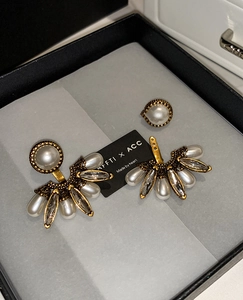 Vue détaillée de boucles d'oreilles perles en éventail vintage avec cristaux sur fond noir