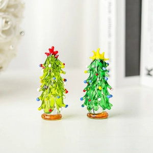 Close-up of two handmade glass Christmas trees with colorful ornaments and star toppers