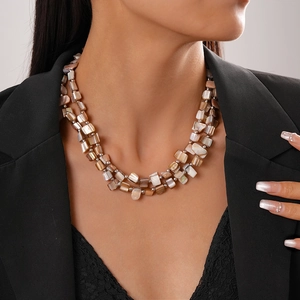 Detail of double-layer necklace with irregular brown shell beads on a model