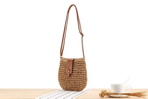 Detail of hand-woven paper rope bag with leather strap and metal button closure