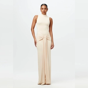 Détail de la robe longue beige montrant le nœud à la taille et le drapé élégant