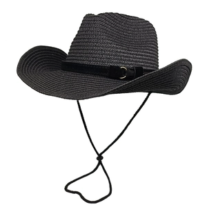 Detail of black straw cowboy hat featuring a spiral weave pattern and gold buckle detail