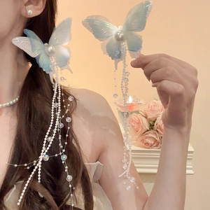 Detail of light blue butterfly hair clip with gradient mesh wings and long beaded tassels