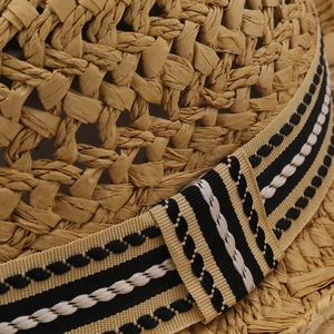 Macro shot of breathable straw weave texture with black and white striped ribbon detail
