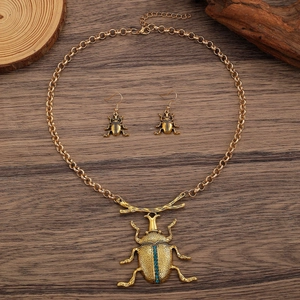 Parure di gioielli coleottero vintage con collana e orecchini su legno scuro