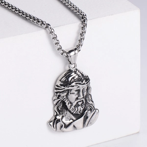 Macro view of silver vintage Jesus Christ pendant with detailed embossed punk texture