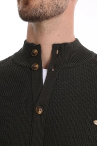 Detail of dark green knit cardigan featuring 3D wave texture and amber buttons