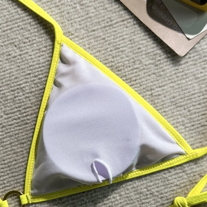 Detail of yellow lace bikini featuring breathable white mesh lining and removable pad pockets