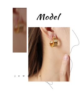 Detailed close-up of a vintage geometric C-shaped earring with golden textured finish