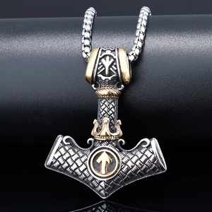Macro shot of silver Mjolnir pendant with gold accents on a textured chain necklace