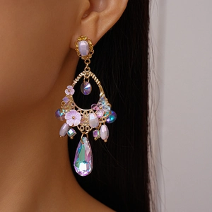 Close-up of vintage gold earrings with purple resin flowers and sparkling crystals on model