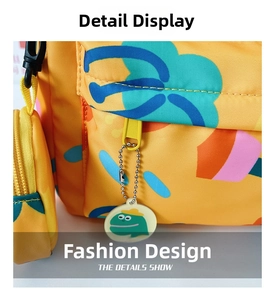 Detail of waterproof nylon backpack with smooth zipper and cute green frog charm