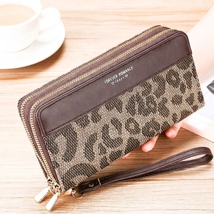 Detail of leopard print long wallet featuring double zippers and a leather wrist strap