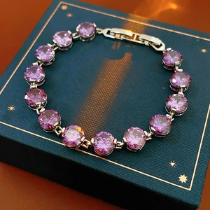 Macro shot of purple round zircon stones set in silver metal with claw setting on bracelet