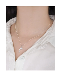 Close-up of minimalist S925 sterling silver dolphin pendant on a delicate chain necklace