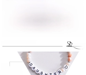 Macro detail of natural stone daughter letter bead bracelet with heart charm and crystals