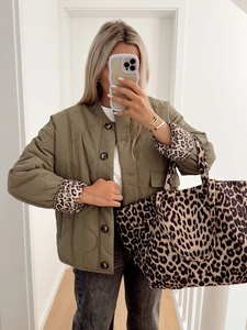Detail of quilted olive green jacket with leopard print cuffs and matching tote bag