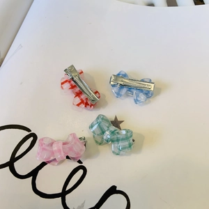 Set of four mini gingham bow hair clips in red, blue, pink, and green with metal duckbill grips