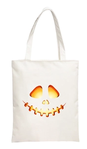 Detailed close-up of a white canvas tote bag featuring a vibrant 2D pumpkin face print