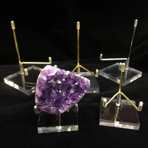 Acrylic display stand with metal arms for crystals and minerals on a black background