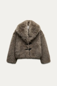 Detail of faux fur jacket with leather buckle closures and plush taupe mink-style texture