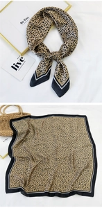 Detail of silk-like leopard print scarf with black borders and elegant tied knot style