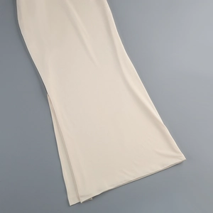 Detailed view of the side slit and smooth beige fabric on this elegant fishtail dress
