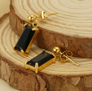 Close-up of gold stainless steel earrings featuring rectangular black zircon stones