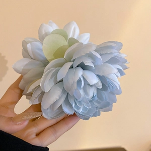 Detail of light blue handmade fabric lotus hair claw clip showing silk petal texture