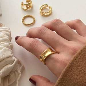 Detail of minimalist 925 silver irregular golden ring set on hand with knit sleeve