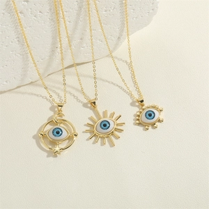 Three gold evil eye necklaces with sun, moon and star charms on white textured stone