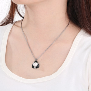 Dettaglio della collana a catena argento con pendente di perla indossata da una modella