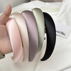 Detail of five padded satin headbands in pastel pink, purple, green, white, and black