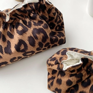 Close-up of leopard print velvet drawstring pouches with soft white fabric lining