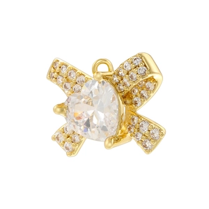 Golden heart pendant with pink bow-tie design and cubic zirconia on white background
