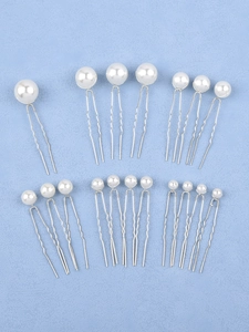 Flat lay of 18 silver U-shaped hair pins featuring various sizes of glossy white pearls