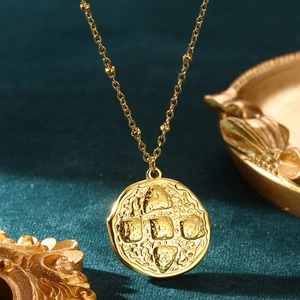 Vintage gold stainless steel necklace with geometric embossed pendant on green velvet