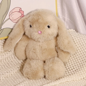 Plush long-eared rabbit doll in soft beige faux fur on a cozy white knit blanket
