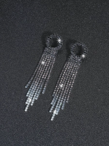 Detailed macro of long rhinestone tassel earrings with a gunmetal finish and sparkling crystals