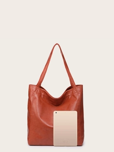 Vue détaillée du sac cabas marron rouge comparé à une tablette dorée sur fond beige uni