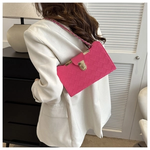Pink quilted shoulder bag with gold chain strap worn by a model in white blazer
