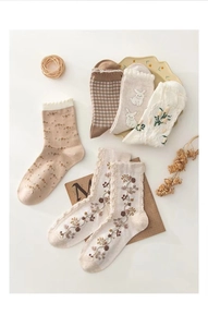 Detail of vintage floral embroidery and cute rabbit patterns on cotton socks