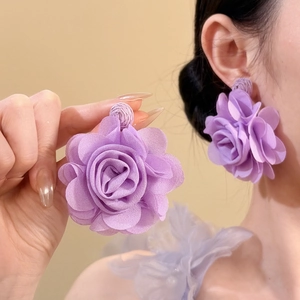 Close-up of large light purple chiffon flower earrings with elegant fabric textures