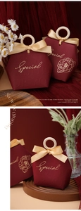 Close-up of burgundy hexagonal gift box with champagne gold ribbon and round wooden handle