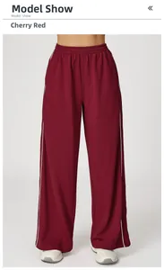 Détail du pantalon de jogging large rouge cerise avec taille élastique et rayures