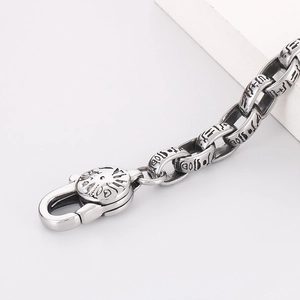 Macro shot of vintage titanium steel chain links with Egyptian hieroglyphs and lobster clasp