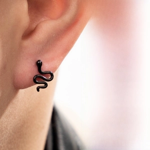 Detailed close-up of a minimalist matte black snake stud earring worn on an ear